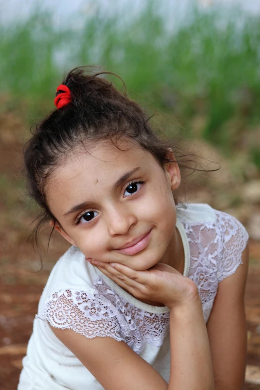 a little girl that is sitting down with her chin resting