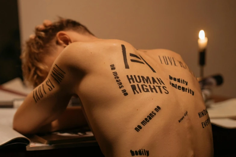 someone has tattoos on their backs and arms