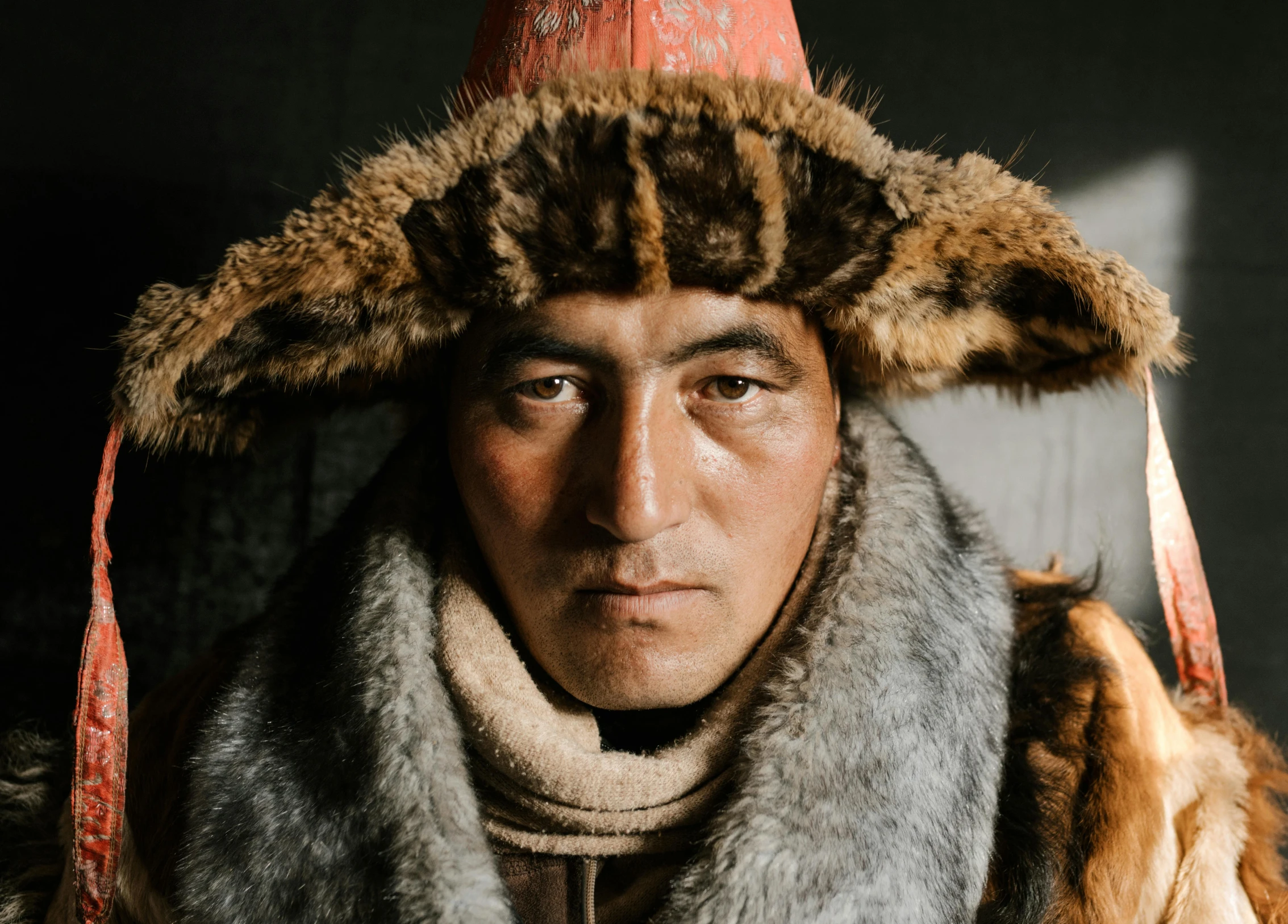 an old man is wearing a fur hat and posing for a picture