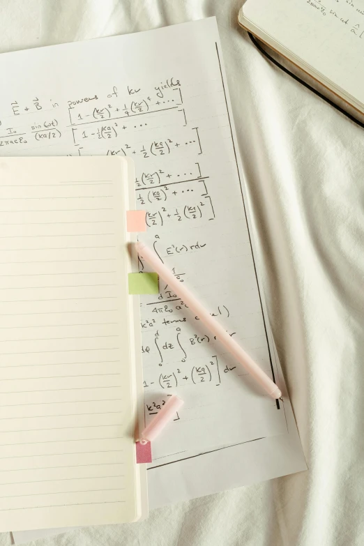a notebook with a pen and some math work on it