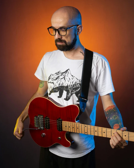 a man holding onto a red guitar in his hand