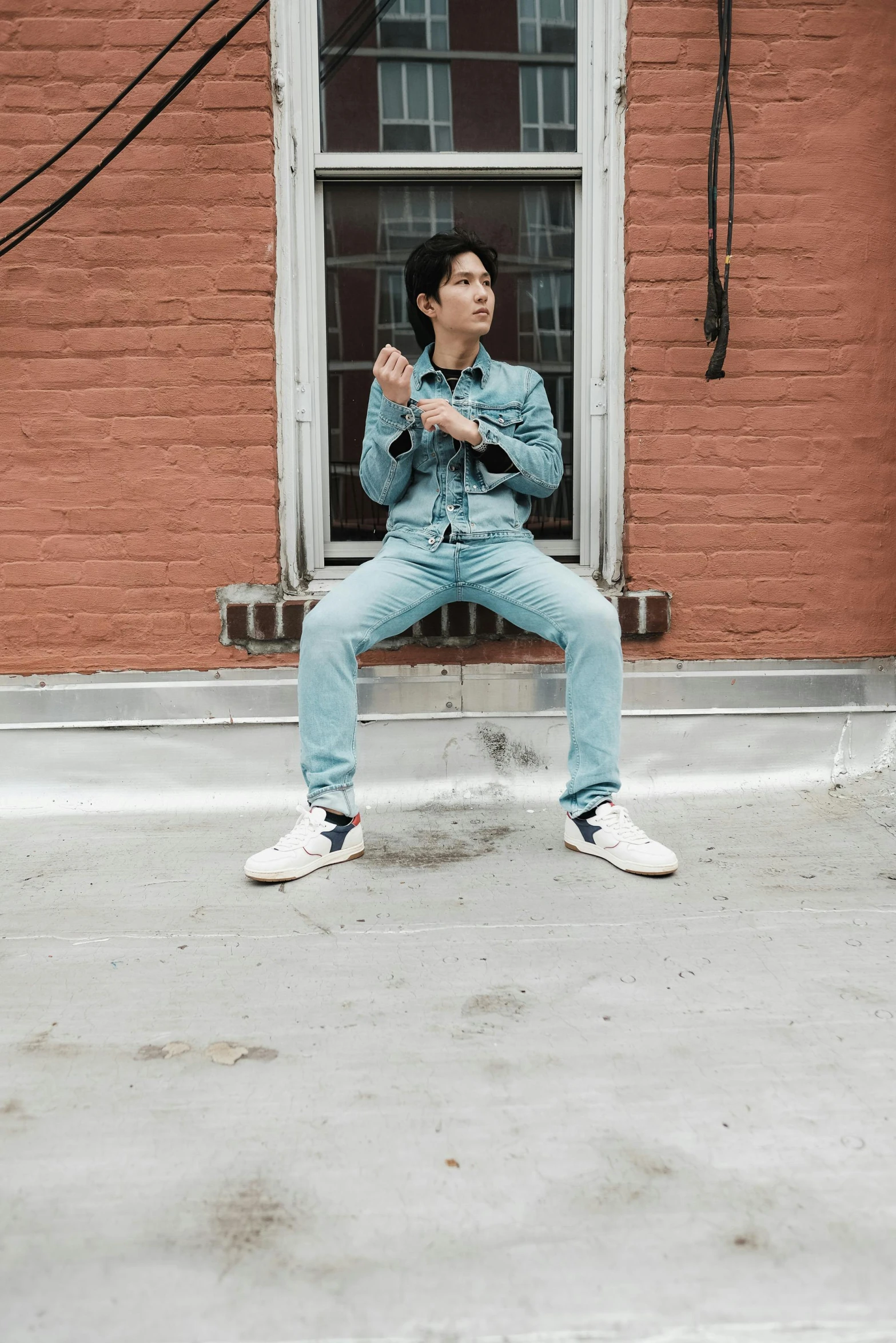 a man sitting on a window sill wearing some white sneakers