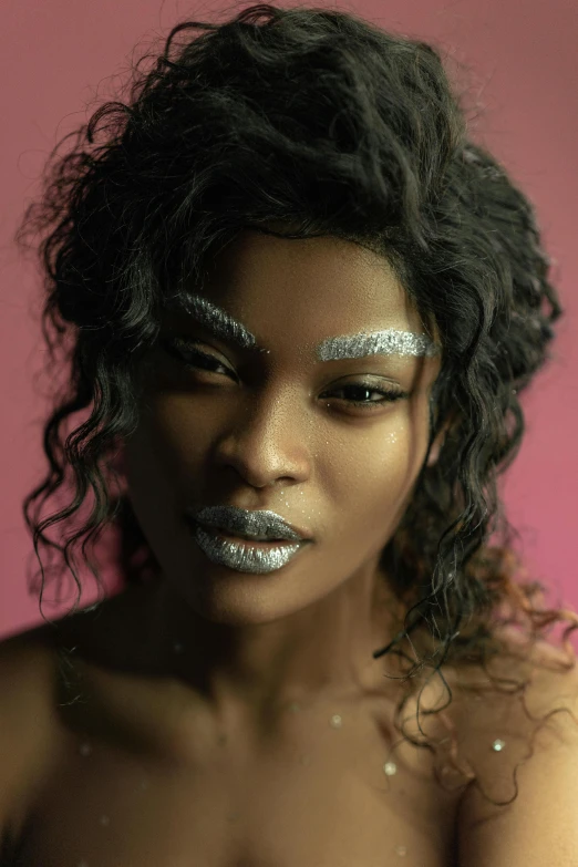 a woman with silver make up and long hair