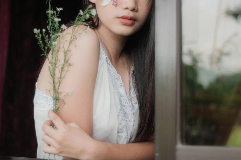 a girl is looking out a window at the camera