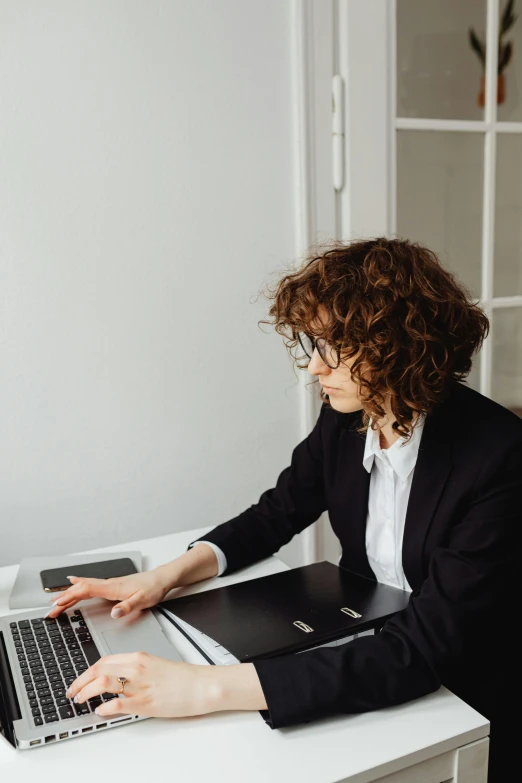 a woman sitting at a table with a laptop