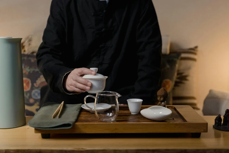 a person pours coffee at a wooden table