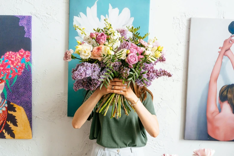 a girl is holding a vase full of colorful flowers