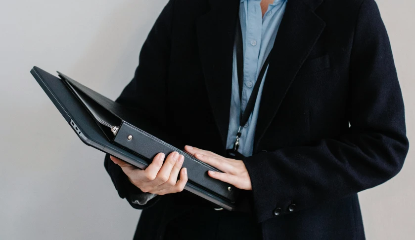 a man standing with his laptop in his hand