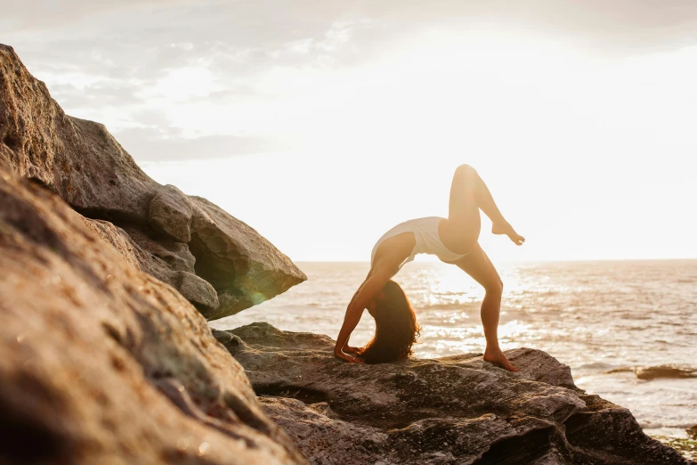 woman doing yoga exercises in front of a cliff