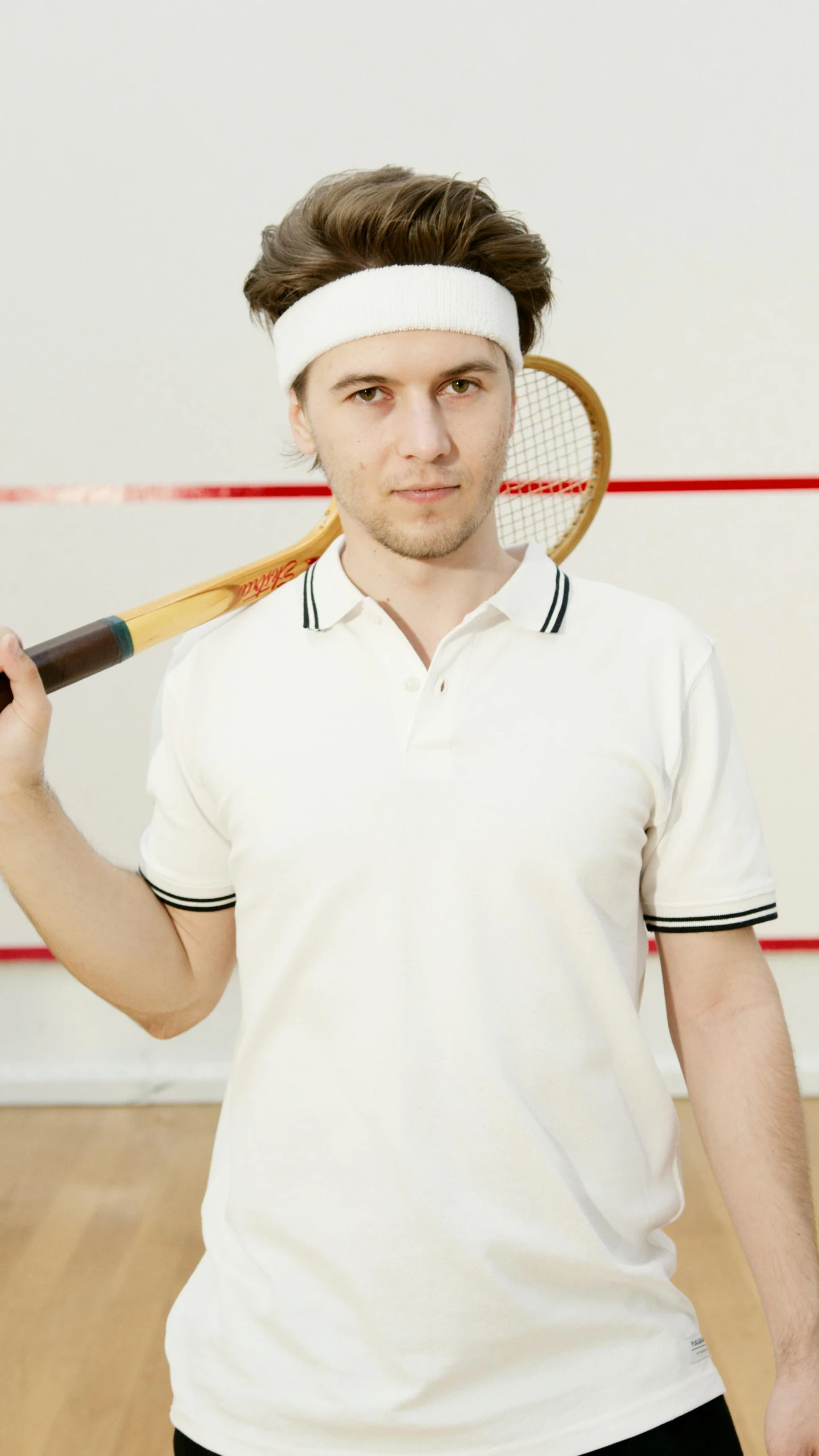 a man is holding a tennis racket to his face