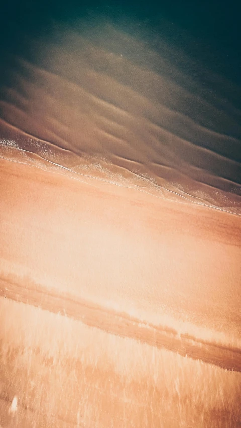 an overhead view of the ocean waves and the beach