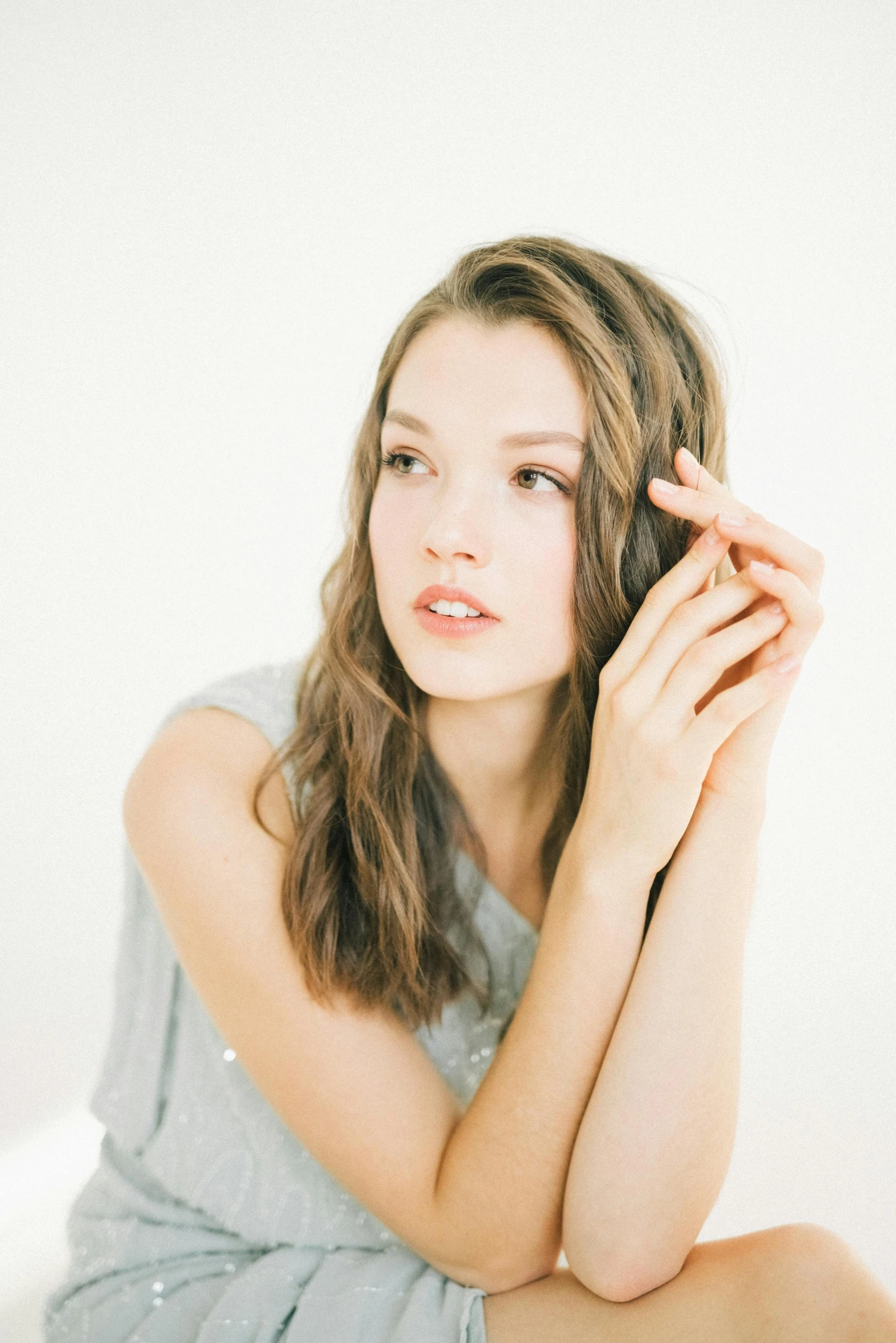 a woman with long hair sits on the floor