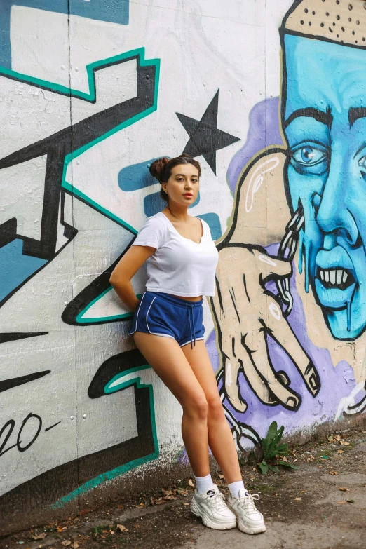 a woman poses for a po in front of graffiti