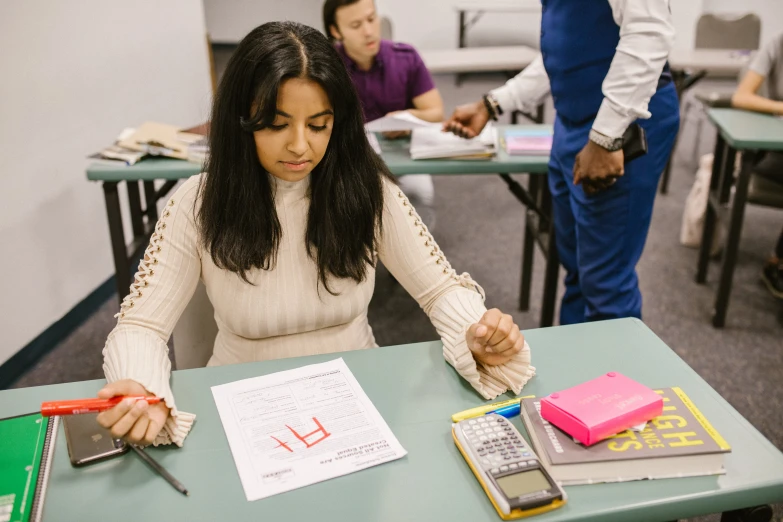 an african american female student is looking over her work