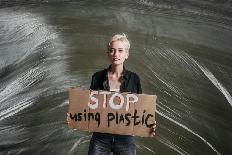 the woman is holding up a cardboard sign