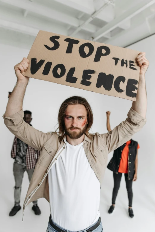 a man holding up a sign that reads stop the violence