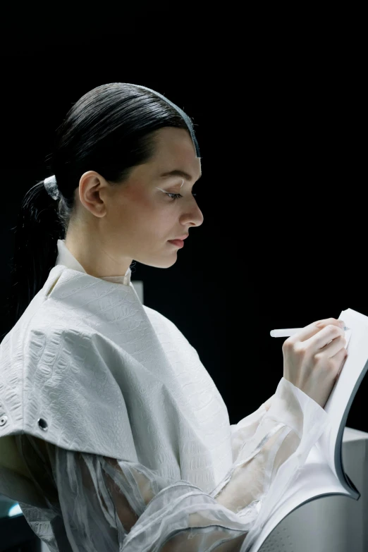 a woman is sitting and reading soing in her hands