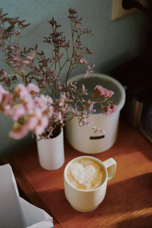 two white containers and a vase with pink flowers