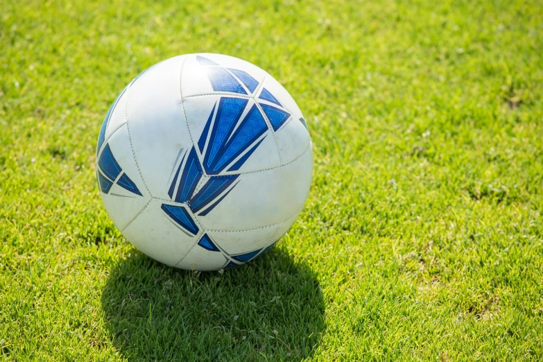 a soccer ball with a pattern is on the grass