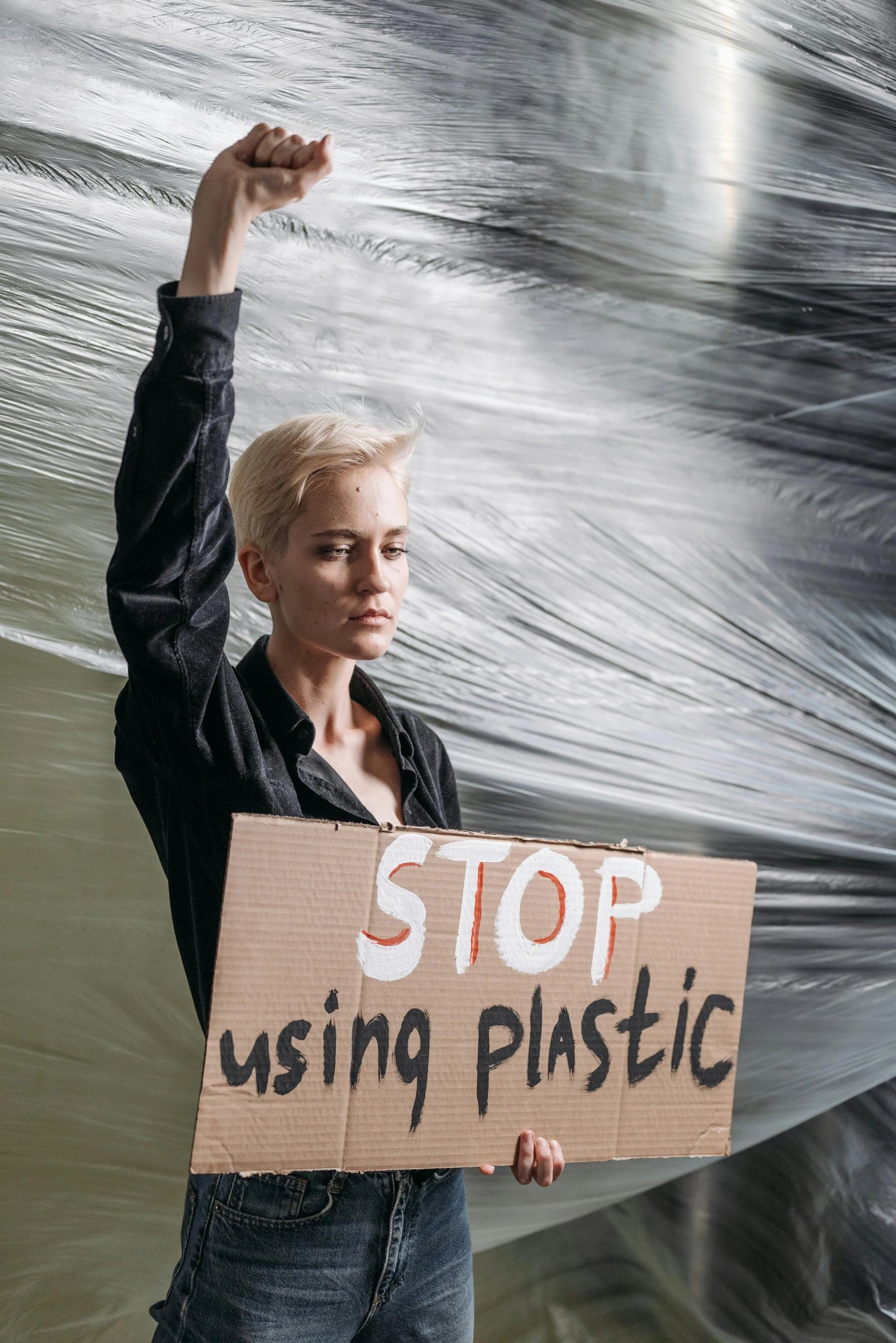 a person holding up a stop using plastic sign