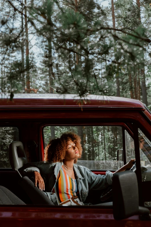 a woman sitting in the back seat of a red truck