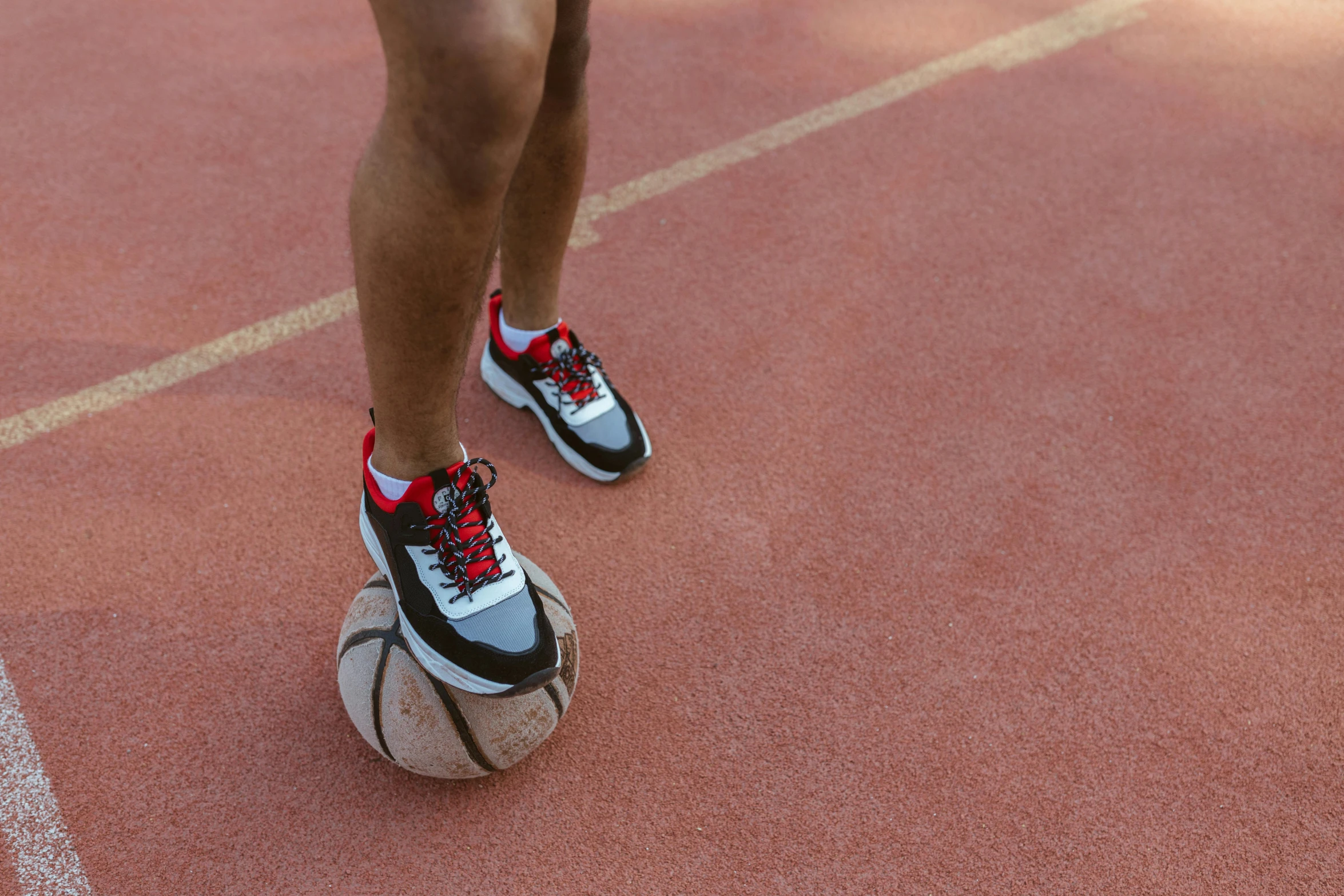 a person in red and black shoes is standing on a tennis court