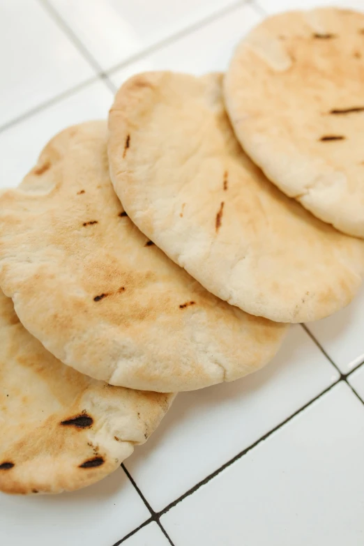 three flat bread is sitting on the tile