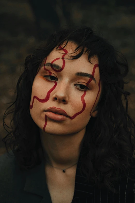 a close up of a person with red painted on her face