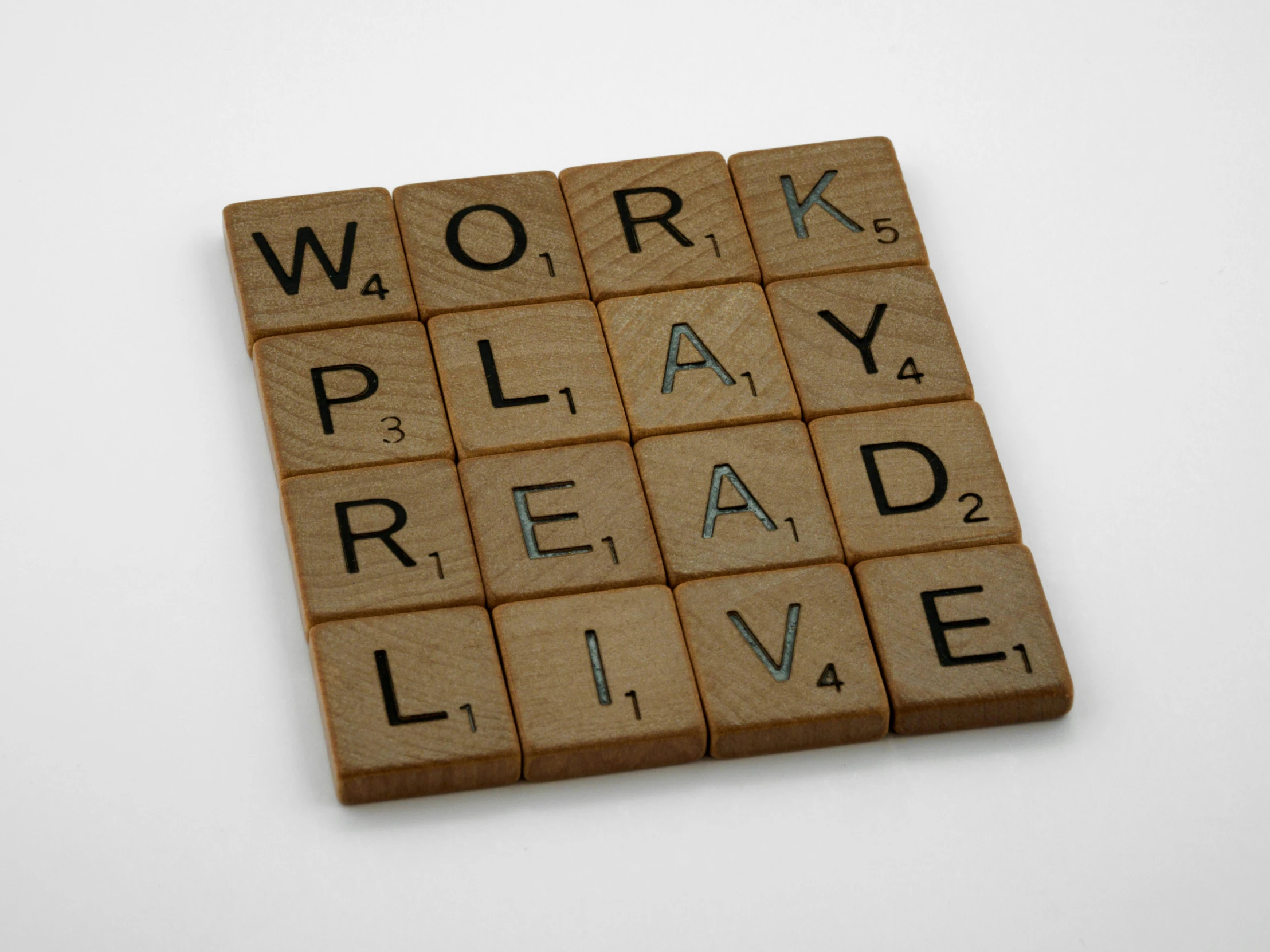 scrabble tiles spelling out words that read work, play, read live