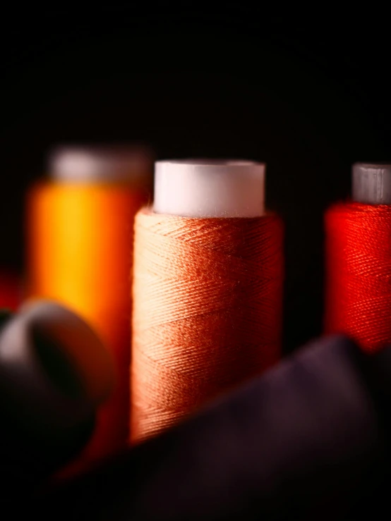 close up of four different colored spools of thread