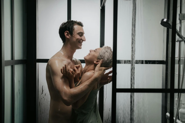 two men in the shower are wet and playing with each other