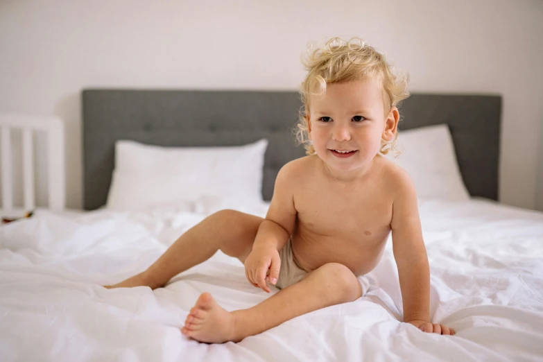 a baby is sitting  on a bed