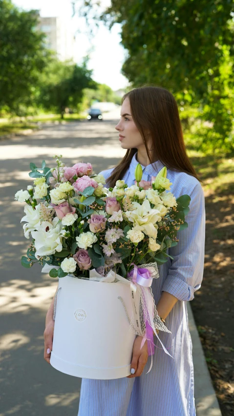 a woman wearing a dress is holding a bucket full of flowers