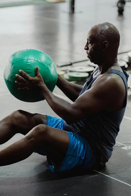 a man holding a green ball while sitting on the ground