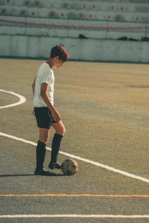 a person is standing with their foot on a soccer ball