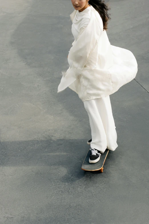 a woman on a skate board in an empty lot