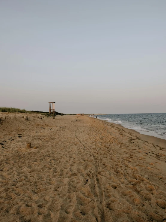 a lone beach chair sitting on a deserted beach