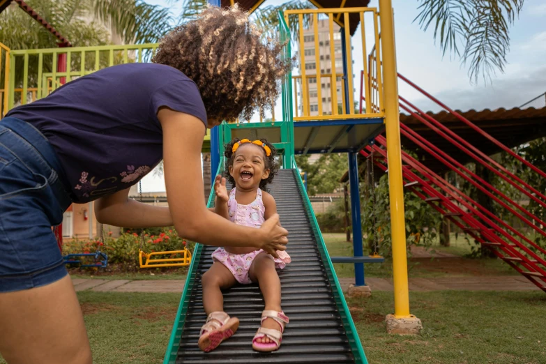 a girl and her mother playing at a playground