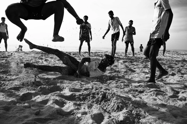 people are playing in the sand with one leg on the ground