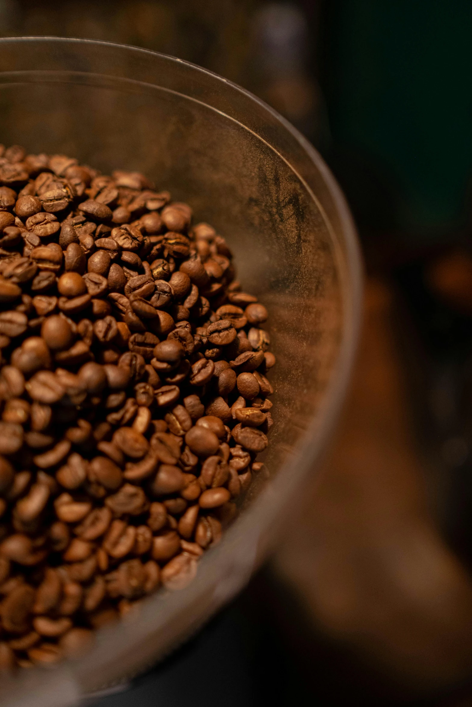 a metal bowl with coffee beans and a spoon