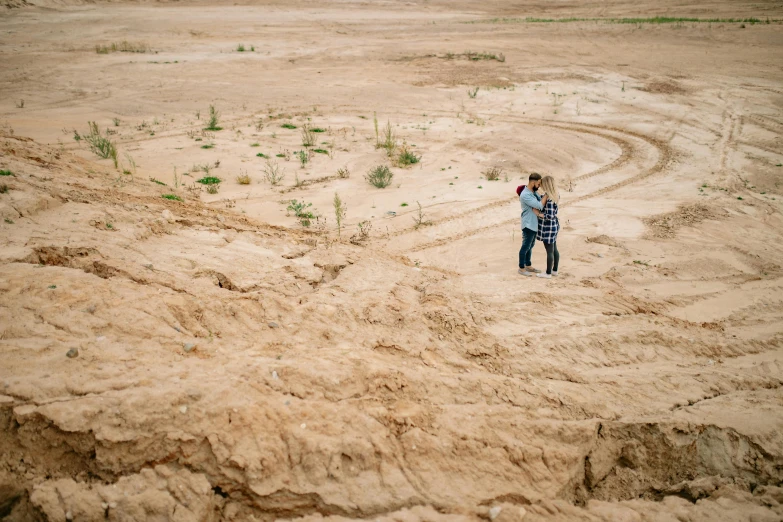 there is a man standing on the dirt looking at soing