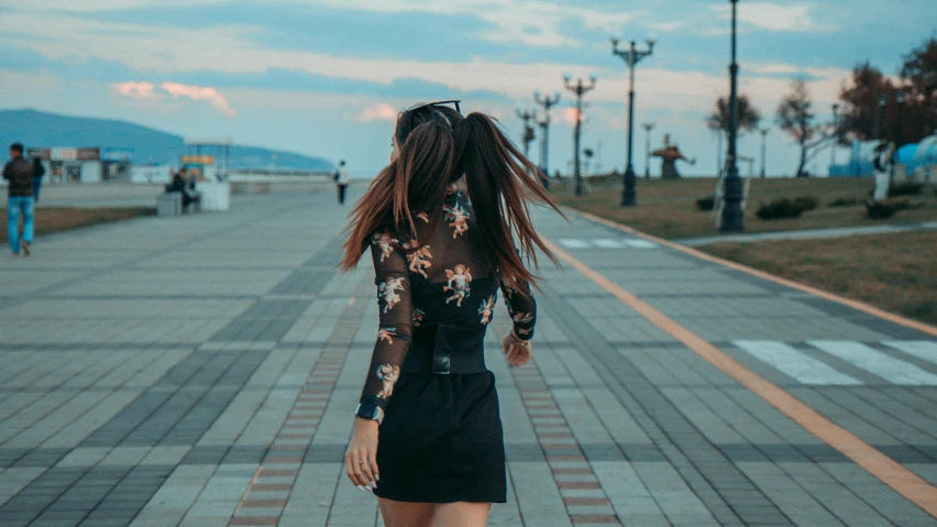 a girl in a short dress is walking down the street