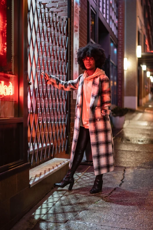 the woman in the coat is standing outside of a restaurant