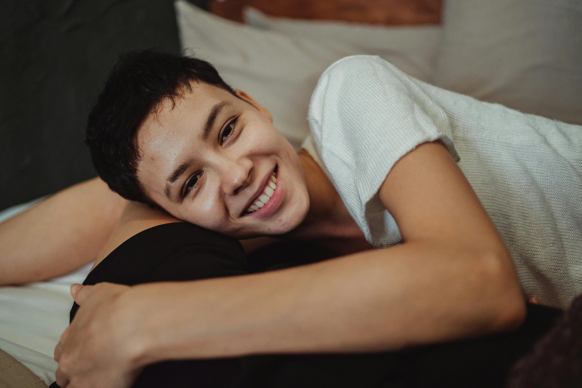 young man laying on the couch smiling for the camera