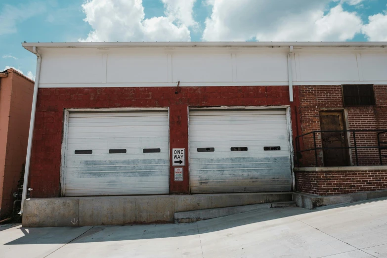 two garage doors are closed near a brick building