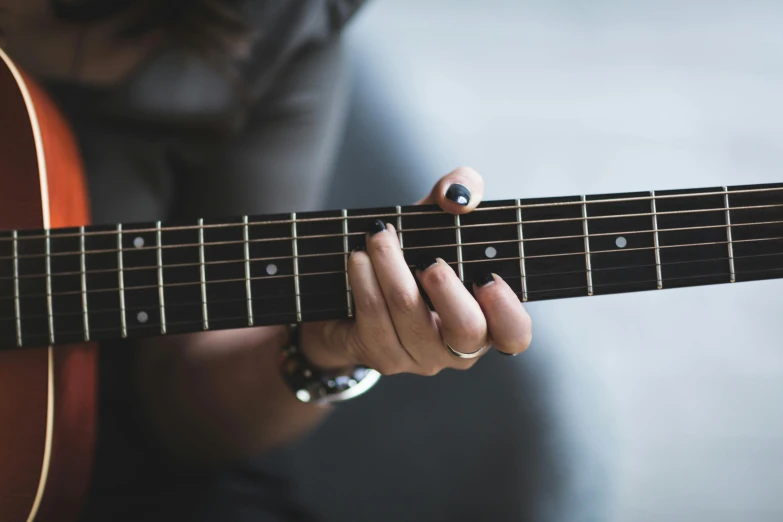 a woman is playing a guitar that has two fingers on it