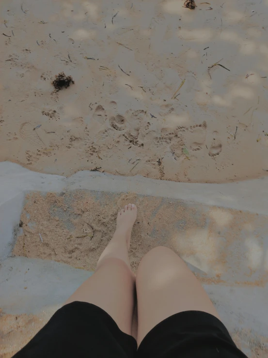 a person with their legs propped up on the beach