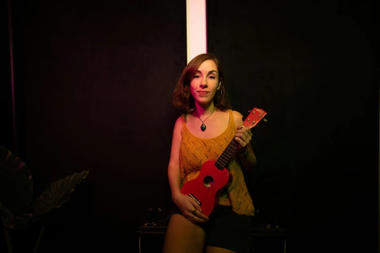 a woman standing with a red instrument in her hands