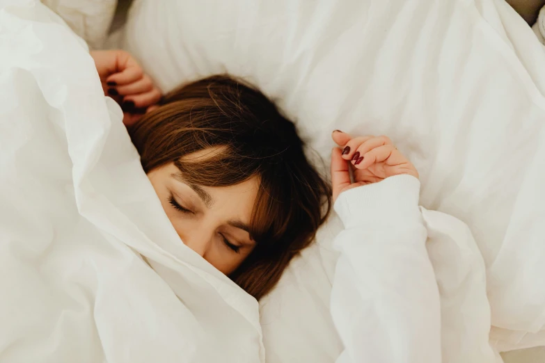 a woman is laying down with her head inside of a pillow