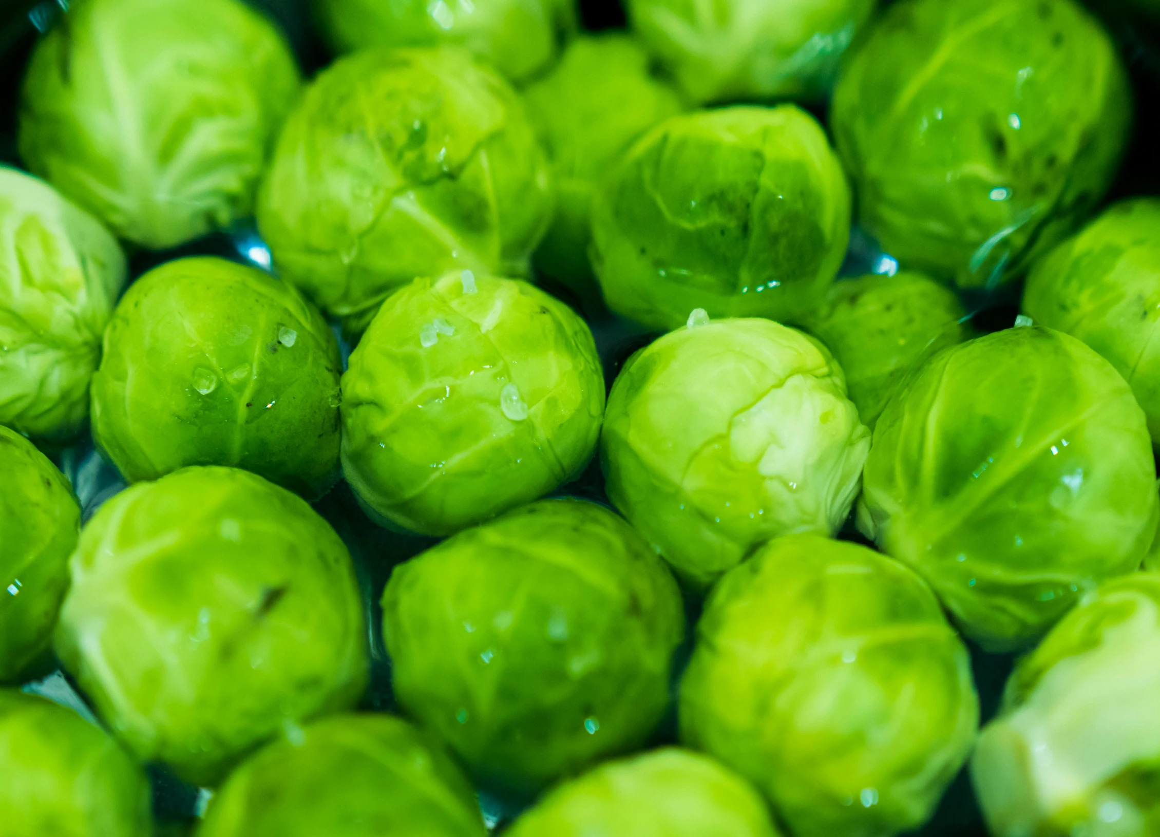 a bunch of green brussels sprouts on top of a white bowl